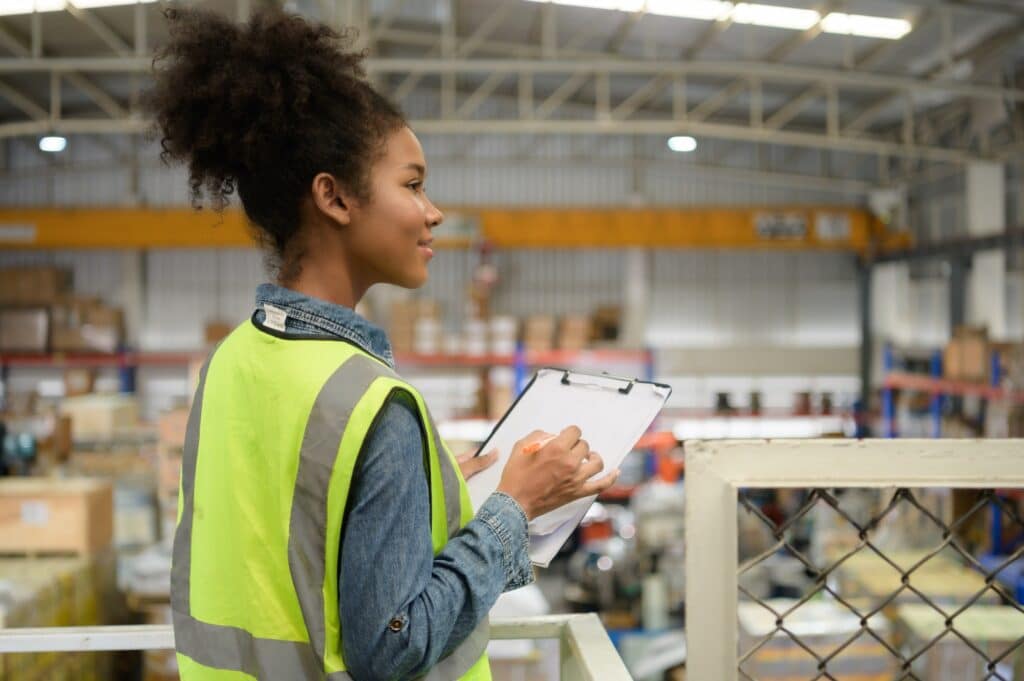 Female warehouse worker Counting items in an industrial warehouse